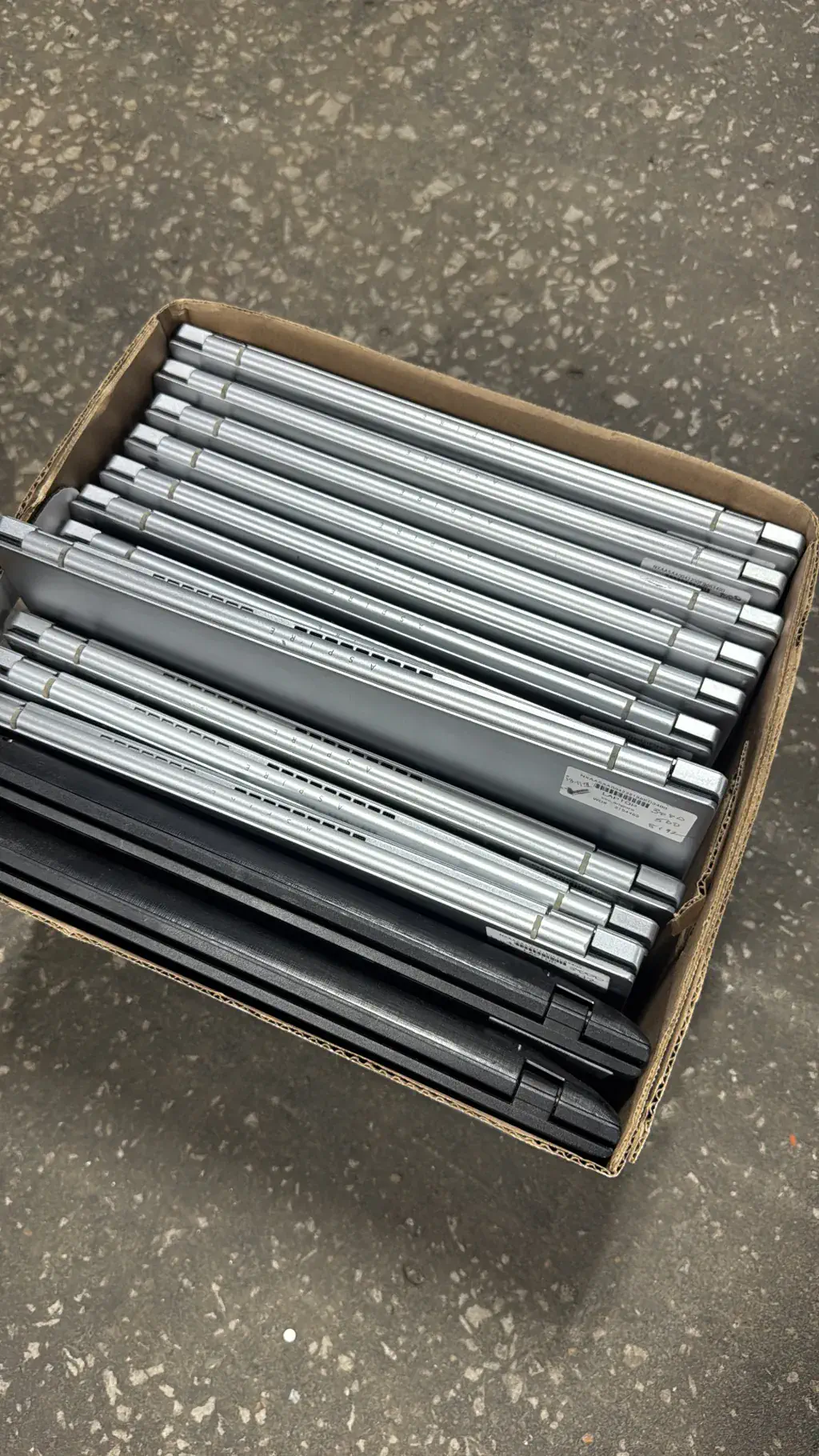 A box of laptops lined up for recycling